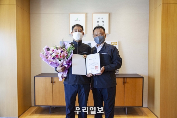 대한민국 명장 김주호 기술부장(좌)을 현대두산인프라코어 손동연 사장(우)이 격려하고 있다.