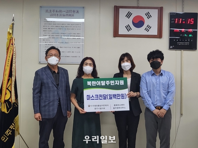 민주평통 한순덕 복지문화분과 위원장(왼쪽에서 두번째)이 충북하나센터 충주협력사무소에 KF94 마스크를전달하고 기념촬영을 하고 있다.(사진=충주시청)