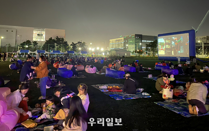 지난 7일 저녁 인천공항 제1물류단지 체육공원에서 열린 ‘인천공항 자유무역지역 가족 초청 가을밤 영화제’에서 물류기업 종사자와 가족들이 영화 ‘한산’을 관람하고 있다. ⓒ 인천국제공항공사 제공