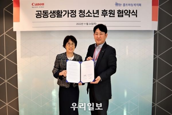 24일 홀트아동복지회 이수연 회장(왼쪽)과 캐논코리아 김정현 캐논코리아 경영지원부문장(오른쪽)이 공동생활가정 청소년 후원 협약을 맺고 기념촬영을 하고 있다.