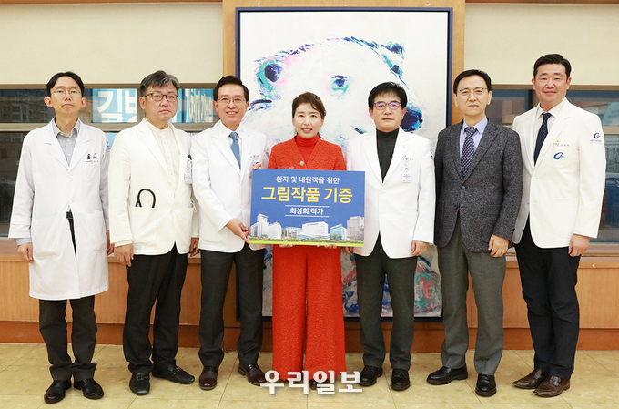 29일 가천대 길병원 월례회 후 최성희 작가(가운데)와 김우경 병원장(가운데 왼쪽) 등 주요 임원들이 작가가 기증한 작품 앞에서 기념촬영 하고 있다. ⓒ 가천대 길병원 제공