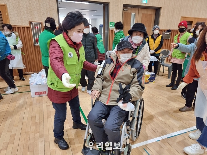 김필례 총재가 ‘버스킹 무료급식 자선공연’ 행사장에 입장하는 어르신을 안내하고 있다.(사진=한국숲사랑총연합회 고양시지회)
