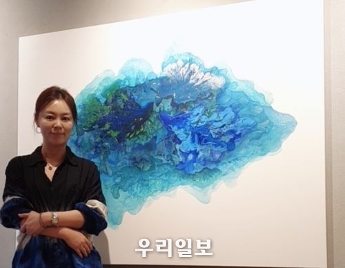 작가 어현경이 꿈꾸는 섬 작품과 포즈를 취하고 촬영을 하고 있다.