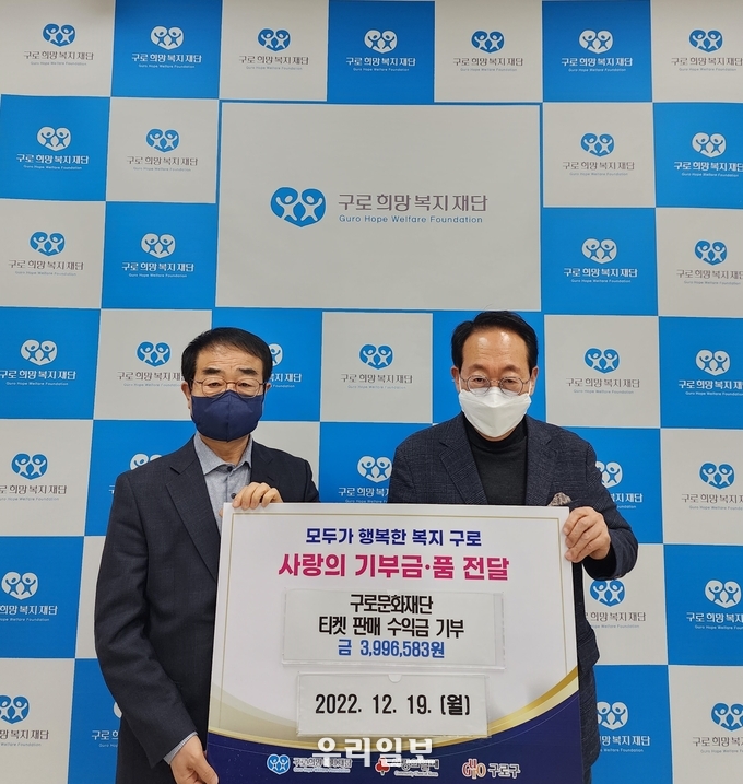 구로희망복지재단 김백수 사무국장과 구로문화재단 정연보 대표이사가 기부금을 전달하고 기념촬영을 하고 있다.(사진=구로문화재단)