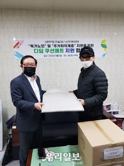 지난해 12월 22일 사단법인 주거복지연대 남상오 이사장(왼쪽)과 ㈜늘디딤 박기황 공동대표이사(오른쪽)이 업무협약을 마치고 디딤쿠션매트를 들고 기념촬영을 하고 있다.