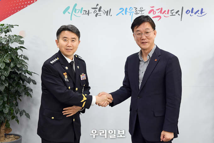 장진수 평택해양경찰서장(왼쪽)과 이민근 안산시장이 악수를 나누며 기념촬영을 하고 있다.(사진=안산시청)