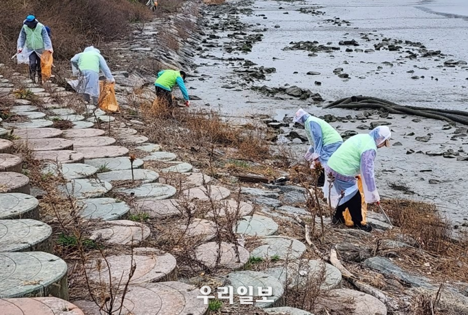 인천희망네트워크 회원들이 학익유수지에서 생태하천 보전을 위한 환경정화활동을 하고 있다.(사진=인천희망네트워크)