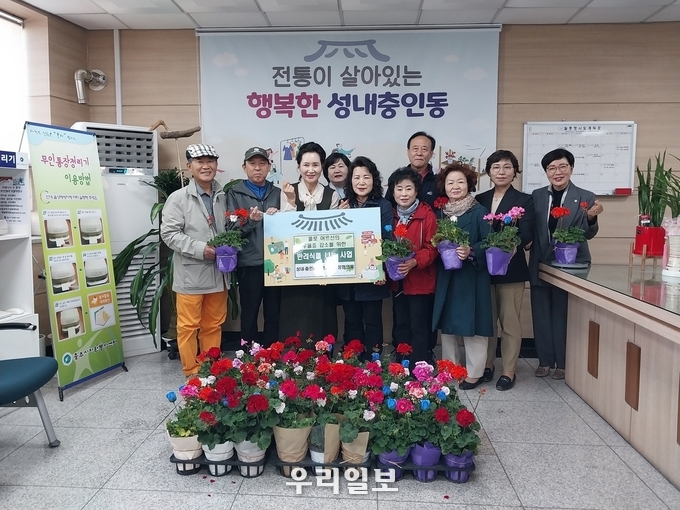 충주시 성내충인동 지역사회보장협의체가 봄을 맞아 홀몸노인 등 복지 사각지대 54가구에 화분 나눠주기 행사를 진행하고 기념촬영을 하고 있다.(사진=충주시청)