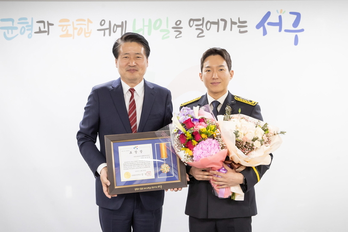 강범석 서구청장이, 14일 중봉지하차도 화재 진압한 강건묵 소방교에 표창 수여하고 기념촬영을 하고 있다. ⓒ 서구청 제공