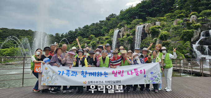 안산시 상록수보건소 치매안심센터가 지역 내 명소인 김홍도 미술관과 노적봉 공원 일원에서 치매 환자와 가족이 함께하는 힐링 나들이를 진행하고 기념촬영을 하고 있다.(사진=안산시청)