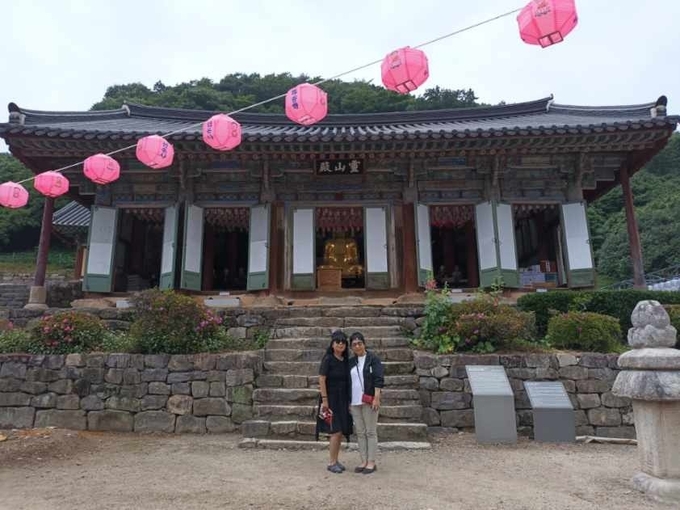 전북 고창 선운사 영산전 목조삼존불상이 장순진 기자(오른쪽)뒤편으로 볼 수 있다.