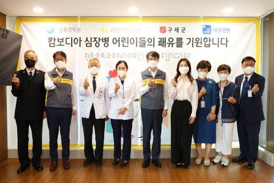 지난 15일 부천 세종병원에서 이명순 금융감독원 수석부원장(좌측 5번째), 김병윤 한국구세군 서기장관(좌측 1번째), 이재근 KB국민은행장(좌측 2번째), 이명묵 부천세종병원장(좌측 3번째), 최민정 KB금융그룹 후원 쇼트트랙 선수(좌측 6번째) 등 관계자들이 '캄보디아 심장병 어린이 의료지원' 을 통해 수술을 마친 아이들을 병문안한 뒤 기념촬영을 하고 있다. ⓒ KB국민은행 제공