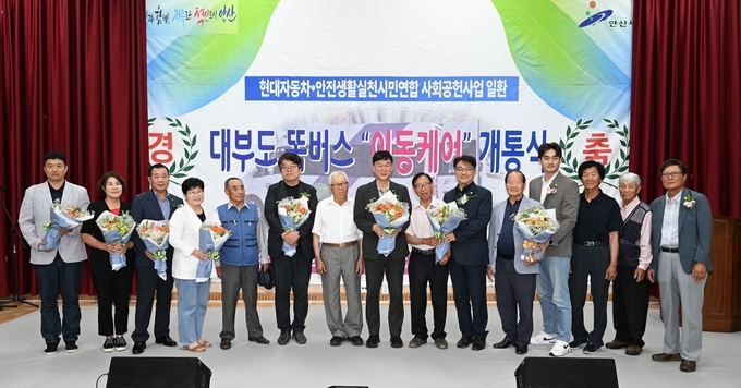 안산시가 교통이 불편한 대부도 지역 어르신 등 이동약자를 위한 신교통 수단인 ‘이동케어 똑버스’ 개통식을 진행하고 기념촬영을 하고 있다.(사진=안산시청)