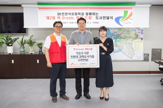 홍욱표 K인천석유화학 경영혁신 실장이, 강범석 서구청장과 김미주 굿네이버스 인천서부지부장에게 ‘작은도서관’ 14곳에 환경도서 등 1,400권 기증서를 전달하고 있다. ⓒ 서구청 제공
