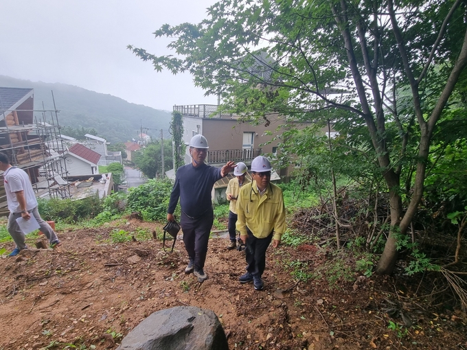 비탈면 붕괴 대비 현장점검에 나선 연제찬 시흥시 부시장이 하우로 주택가 인근 비탈면과 옹벽 등을 둘러보며 위험요소를 살피고 있다.ⓒ시흥시 제공