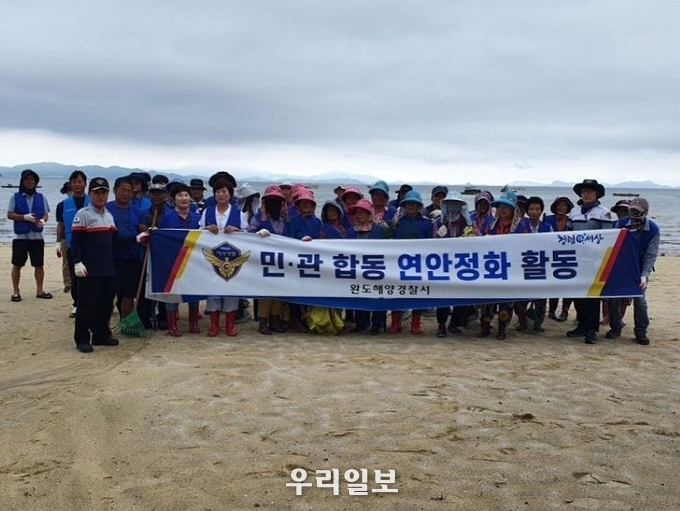 완도해양경찰서가 장흥 수문 해수욕장에서 민·관 합동 연안정화 활동을 진행하고 기념촬영을 하고 있다.ⓒ완도해양경찰서 제공