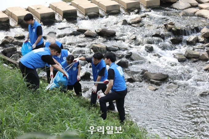 지난 13일 오후 인천 부평구 굴포천에서 신천지 청년자원봉사단 '위아원'이 환경정화 봉사활동을 하고 있다(사진제공=마태지파 문화부)