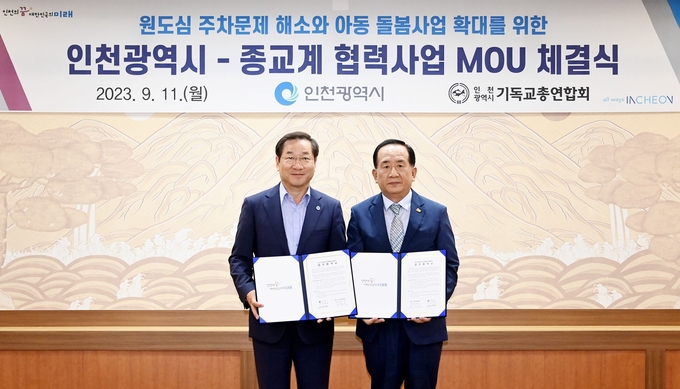 유정복 인천시장이 11일 시청 접견실에서 열린 원도심 주차문제 해소와 아동 돌봄사업 확대를 위한 '인천광역시-종교계 협력사업 MOU 체결식'에서 인천기독교연합회 진유신 총회장과 협약을 체결한 뒤 기념촬영을 하고 있다. ⓒ 인천시 제공
