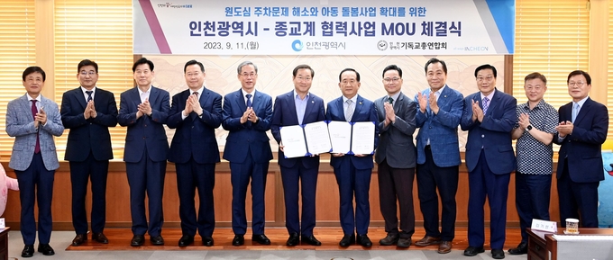 유정복 인천시장이 11일 시청 접견실에서 열린 원도심 주차문제 해소와 아동 돌봄사업 확대를 위한 '인천광역시-종교계 협력사업 MOU 체결식'에서 인천기독교연합회 진유신 총회장과 협약을 체결한 뒤 기념촬영을 하고 있다. ⓒ 인천시 제공