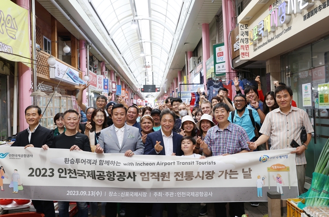 13일 인천국제공항공사가 진행한 ‘인천공항 환승객과 함께하는 신포국제시장 방문행사’에서 인천국제공항공사 이학재 사장(사진 앞줄 왼쪽에서 네 번째) 및 임직원과 인천공항 환승투어객들이 기념촬영을 하고 있다. ⓒ 인천국제공항공사 제공