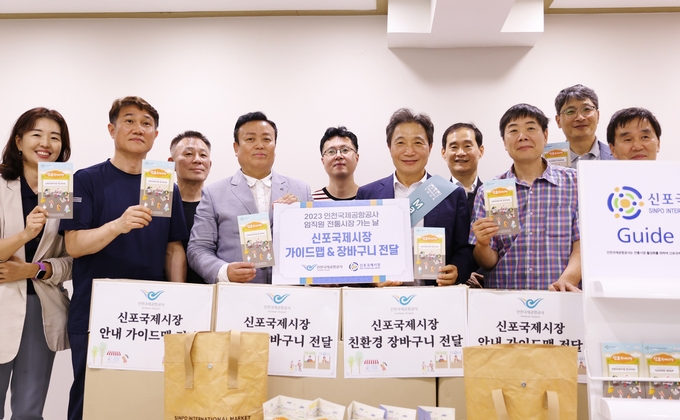인천국제공항공사가 진행한 ‘인천공항 환승객과 함께하는 신포국제시장 방문행사’에서 인천국제공항공사 이학재 사장(사진 앞줄 왼쪽에서 네 번째)이 신포국제시장 상인회에 5개 국어로 된 가이드맵과 친환경 보냉 장바구니 등을 제작해 전달한 후 신포국제시장 상인회 신현기 회장(사진 앞줄 왼쪽에서 세 번째) 및 관계자들과 기념촬영을 하고 있다. ⓒ 인천국제공항공사 제공
