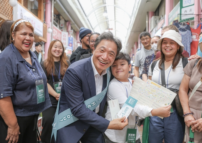 인천국제공항공사가 진행한 ‘인천공항 환승객과 함께하는 신포국제시장 방문행사’에서 인천국제공항공사 이학재 사장(사진 앞줄 왼쪽에서 두 번째)이 인천공항 환승투어객들과 기념촬영을 하고 있다.ⓒ 인천국제공항공사 제공