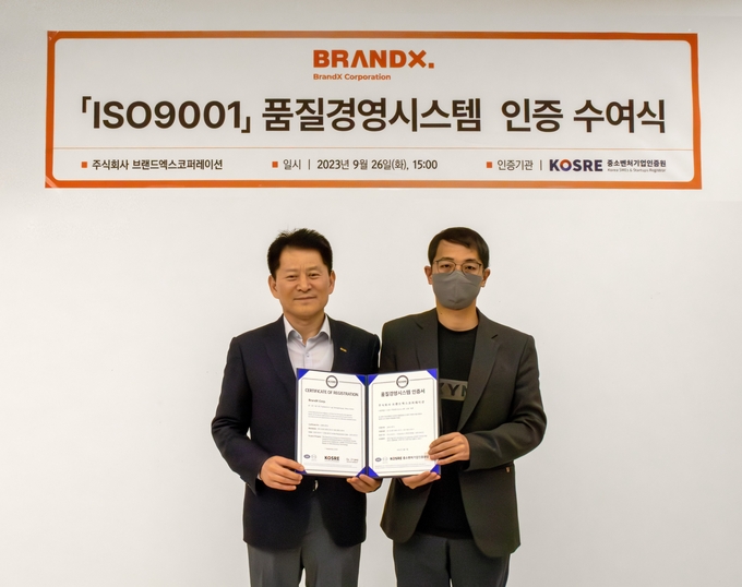 중소벤처기업인증원(KOSRE) 엄진엽 원장(왼쪽)과 브랜드엑스코퍼레이션 이광호 경영지원그룹 이사가 ISO 9001(품질경영시스템) 인증서 수여식 후 함께 기념촬영을 하고 있다.ⓒ중소벤처기업인증원 제공