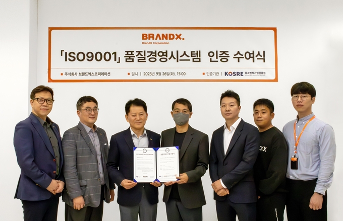 중소벤처기업인증원(KOSRE) 엄진엽 원장(왼쪽 세 번째)과 브랜드엑스코퍼레이션 이광호 경영지원그룹 이사(왼쪽 네 번째) 및 양 기관 주요 관계자들이 ISO 9001(품질경영시스템) 인증서 수여식 후 함께 기념촬영을 하고 있다.ⓒ중소벤처기업인증원 제공