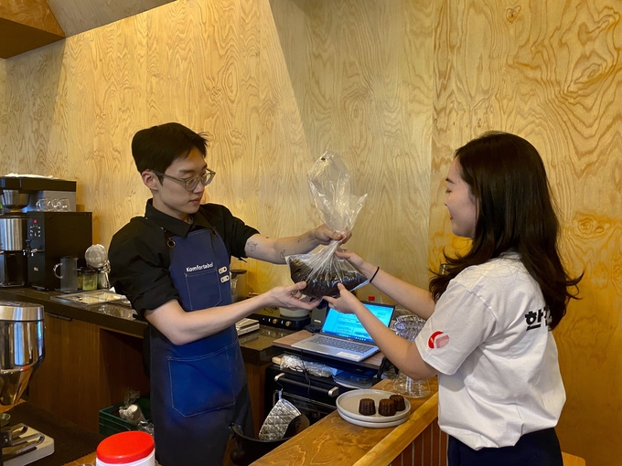 친환경 화분 제작에 필요한 커피박(커피찌꺼기)를 한전산업개발 1층 카페에서 수거하고 있다. ⓒ 한전산업 홍보실 제공