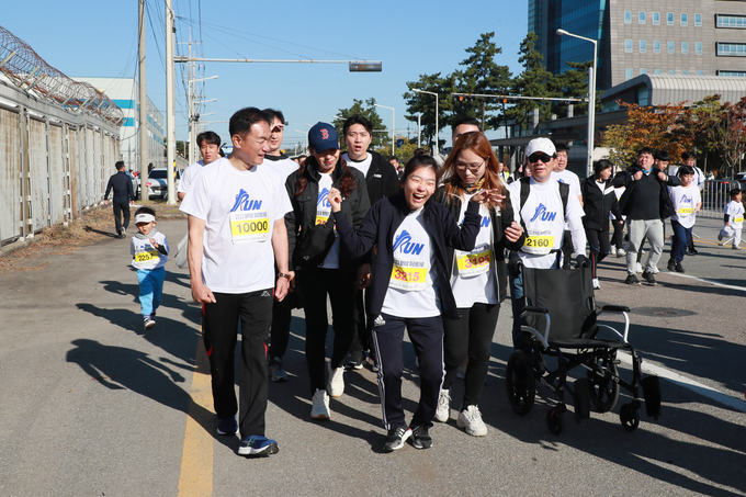정장선 평택시장이 이창희씨가 뇌성마비 장애를 극복하고 평택항 마라톤 참가하고 있는 가운데 함께하고 있다. ⓒ 평택시 제공