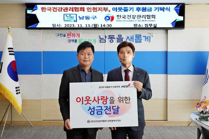 한국건강관리협회 인천시지부 현재식 본부장(오른쪽)이 박종효 인천남동구청장에게 이웃사랑을 위한 성금을 전달하고 기념촬영을 하고 있다.ⓒ한국건강관리협회 인천시지부 제공