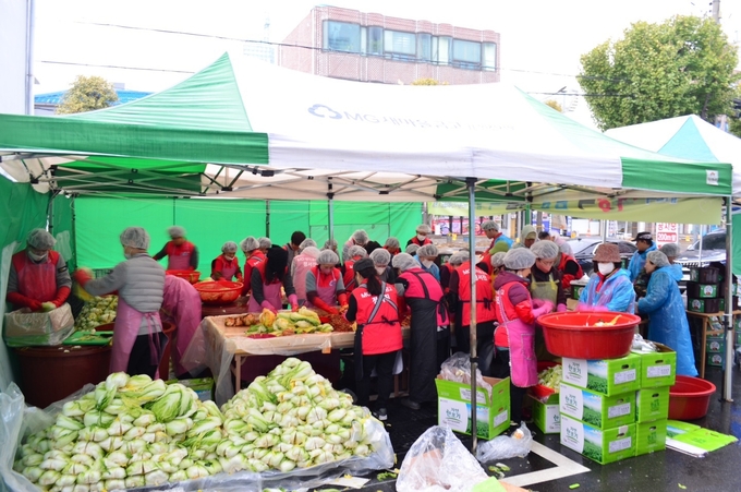 정서진새마을금고 임직원들과 제12회 사랑의 김장 나눔 축제에 봉사자들과 함께 김장속을 버물이고 있다. ⓒ 정서진새마을금고 제공