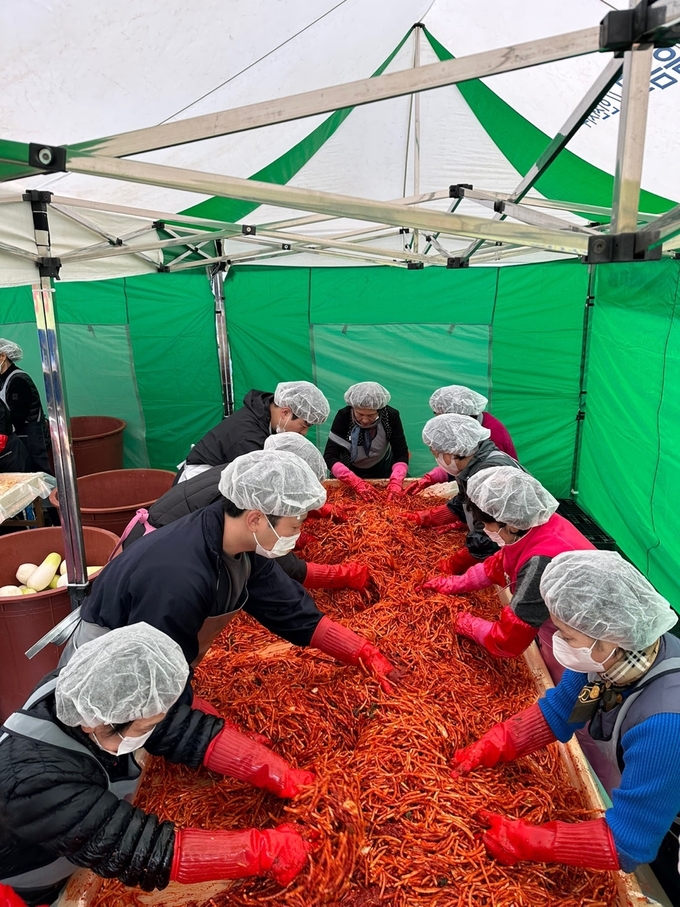 정서진새마을금고가 제12회 사랑의 김장 나눔 축제에 봉사자들과 함께 김장속을 버물이고 있다. ⓒ 정서진새마을금고 제공