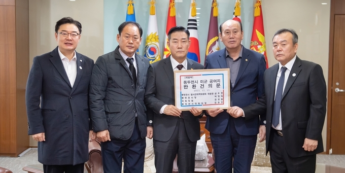 박형덕 동두천시장,김성원의원,김승호의장,심우현 위원장이 신원식 국방부장관에게 동두천시 미군 공여지 반환건의문을 전달하고 있다. ⓒ 동두천시 제공