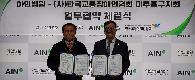 아인의료재단 아인병원 권순표 행정원장과 한국교통장애인협회 미추홀지회 윤태섭 지회장이 MOU체결후 기념촬영을 하고 있다. ⓒ 우리일보 db