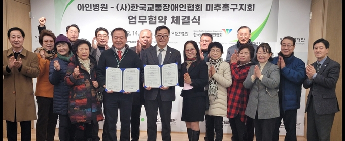 아인의료재단 아인병원 권순표 행정원장과 한국교통장애인협회 미추홀지회 윤태섭 지회장이 MOU체결후 단체 기념촬영을 하고 있다. ⓒ 우리일보 db