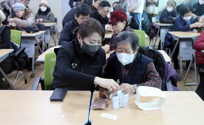한전산업개발 박신옥 대외협력실장이 복지관 어르신과 함께 친환경 화분을 만들고 있다. ⓒ 한전산업개발 제공