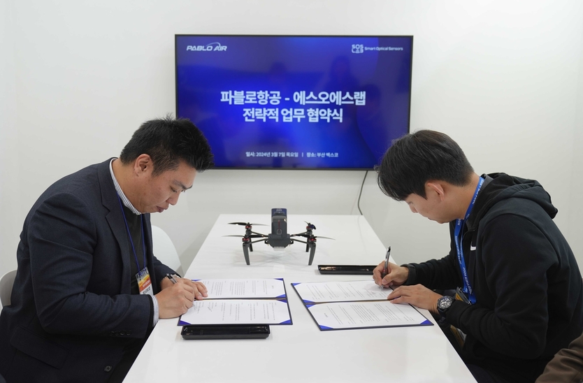 2024 드론쇼코리아에서 김영준 파블로항공 대표와 에스오에스랩 정지성 대표가 MOU 체결식에서 사인을 하고 있다. ⓒ 파블로항공 제공