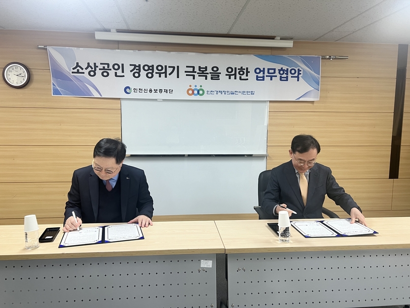 인천신용보증재단 전무수 이사장과 인천경제정의실천시민연합 이종일 공동대표가 헙무협약 체결 서명을 하고 있다. ⓒ 인천신보 제공