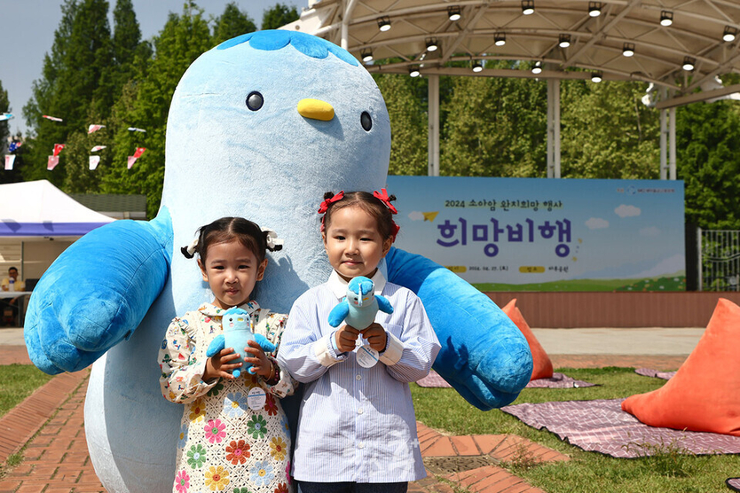 소아암 어린이 완치 희망행사에 참여한 어린이들이 새마을금고 블루원정대 캐릭터 미루와 사진촬영을 하고 있다ⓒ 새마을금고중앙회 제공