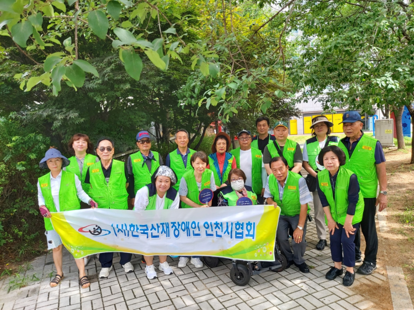 사)한국산재장애인 인천시협회가 미추홀구 숭의동 홈플러스와 장안사거리 일대에서 7월을 맞이해 20여명이 참석한 가운데 환경 정화 활동 캠페인을 펼치고 기념촬영을 하고 있다. ⓒ 한국산재장애인 인천시협회 제공