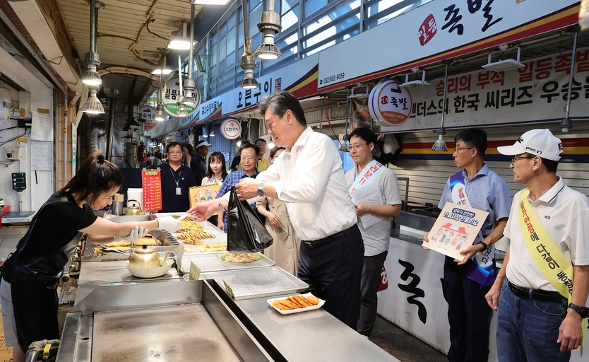 이영훈 구청장이 추석명절을 맞아 전통시장을 찾아 상인들의 손수 만든 음식을 구매하고 있다. ⓒ 미추홀구 제공