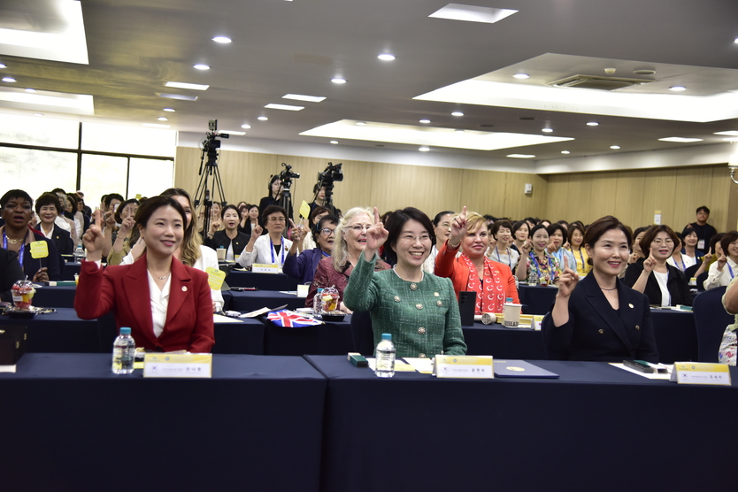 윤현숙 대표와 ‘평화를 실천하는 여성의 리더십’ 참석자들이 위아원을 외치며 기념촬영을 하고 있다. ⓒ 우리일보db