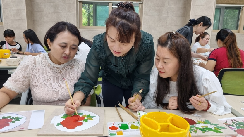 이지영 작가와 제자들이 함께해 다문화 가족이 완성도 높은 민화 작품을 만들 수 있도록 도움을 주고 있다. ⓒ 한국미술협회 제공