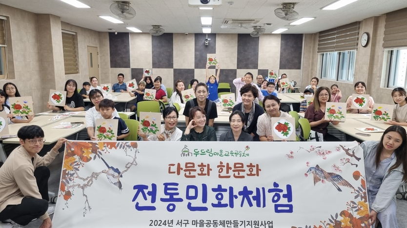 이지영 작가와 제자들이 함께 참여해 다문화 가족이 완성도 높은 전통민화체험을 한 후 기념촬영을 하고 있다. ⓒ 한국미술협회 제공