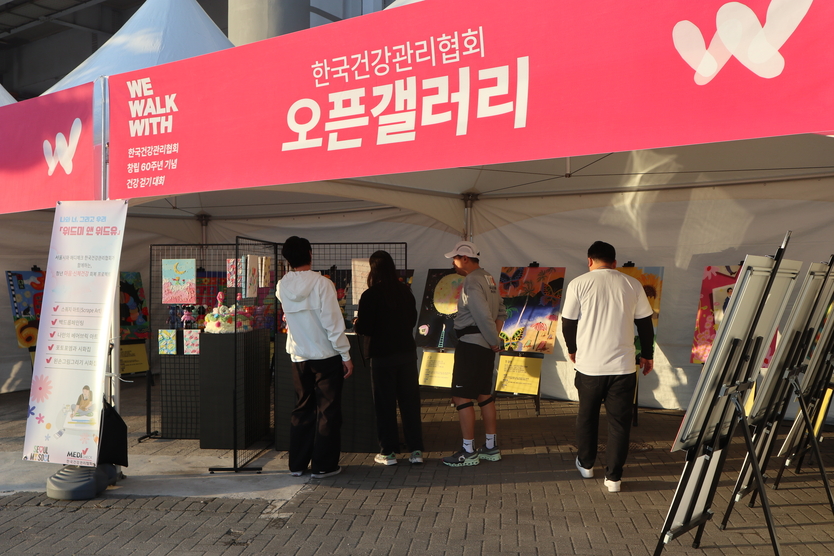 건강걷기대회 참가자 및 일반 시민들이 배리어프리 전시를 관람하고 있다.(사진=한국건강관리협회)<br>
