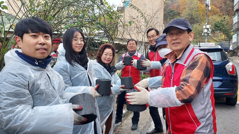 조동암 회장을 비롯한 행정동우회 회원들이 "따뜻한 사랑을 나누는 연탄봉사"활동을 펼치고 있다., ⓒ 우리일보 db
