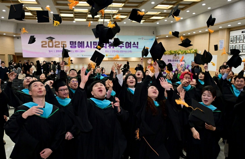 12일 시청 대회의실에서 열린 '2025 명예시민학위 수여식'에서 학위 취득자들이 학사모를 던지는 퍼포먼스를 하고 있다. ⓒ 인천시 제공
