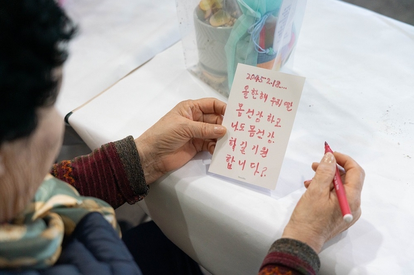 . 지난 18일 주안지부가 준비한 카드에 미망인회 회원이 딸에게 덕담 메시지를 작성 후 읽고 있는 모습.ⓒ신천지자원봉사단 주안지부