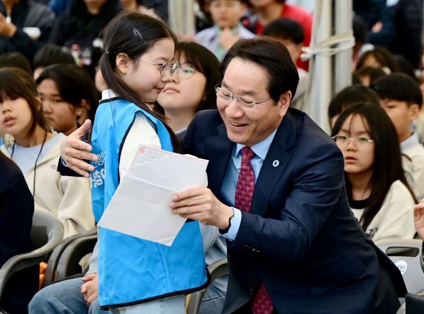 유정복 인천시장(오른쪽)이 인천 문학경기장에서 열린 어린이 축제 현장에서 한 통의 손편지를 받고 있다.